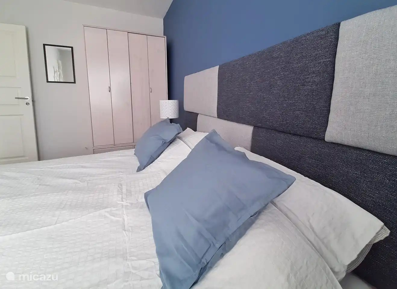 Ein Schlafzimmer mit Boxspringbett und modernen Möbeln