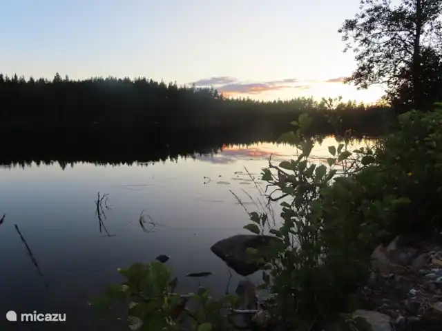 Location de Vacances Suède, Värmland, Nykroppa, maison de vacances - Maison GWEN en lac +service complet vers le soir, le ciel change et les arbres se reflètent dans le lac immobile.