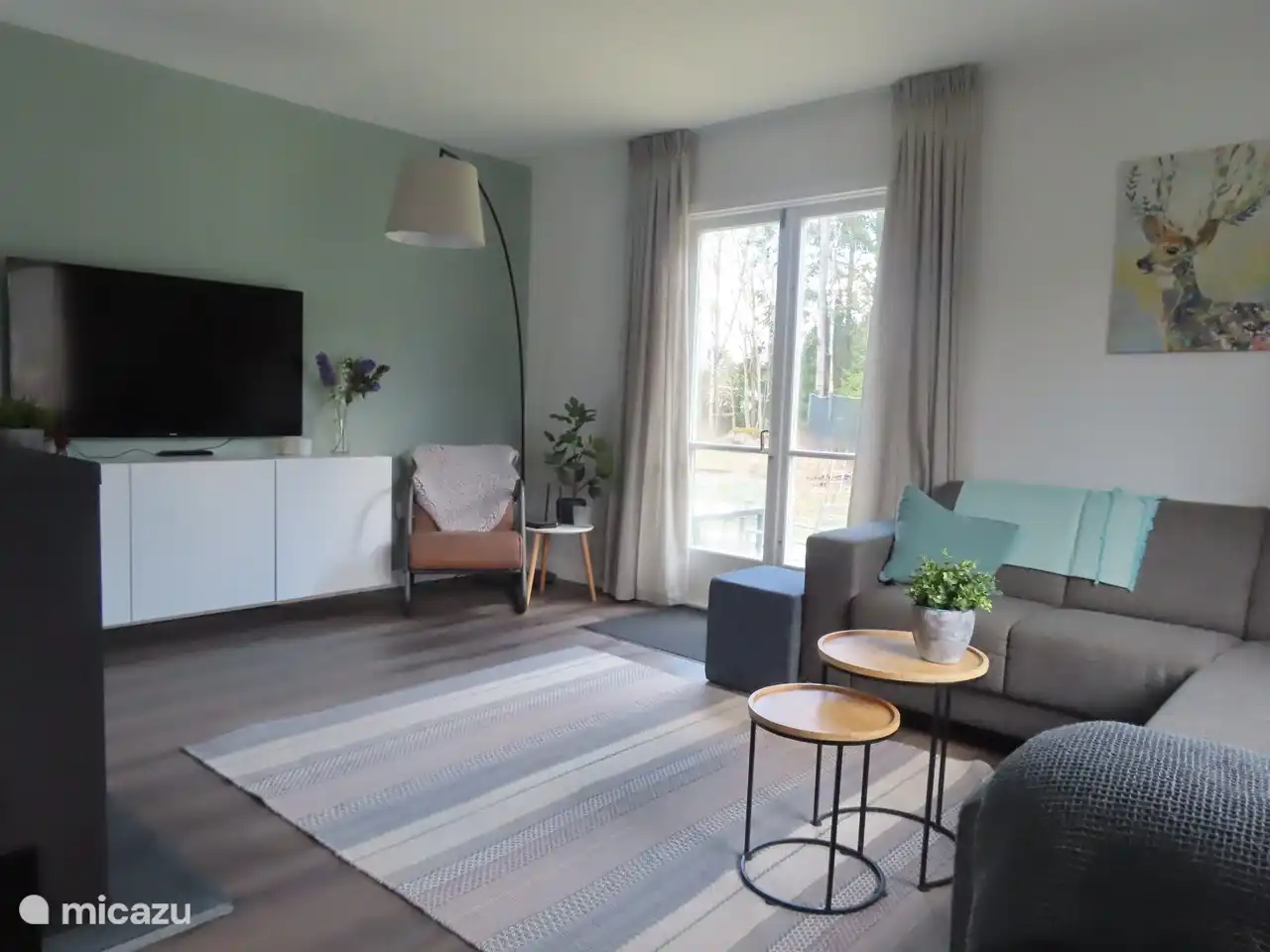 Ein schönes Ecksofa und eine Leseecke mit einem bequemen Stuhl. Der Holzofen sorgt für die nötige Wärme und Gemütlichkeit.