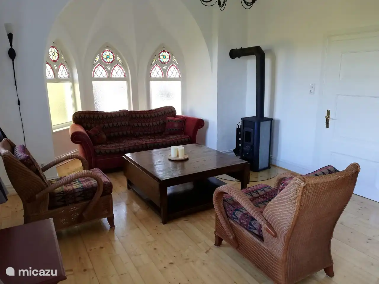 Das Wohnzimmer mit einem schönen authentischen Erkerfenster, einer geräumigen Sitzecke und einem gemütlichen Holzofen.