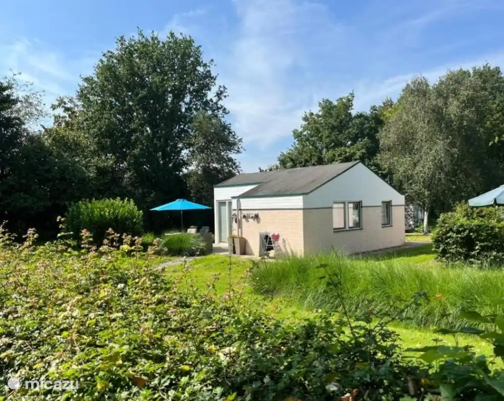 Vorderansicht des schönen Ferienhauses. Viel Grün und ein großer Garten, in dem Sie wählen können, ob Sie in der Sonne oder im Schatten sitzen möchten 