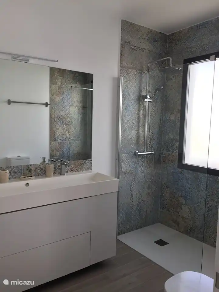 Bathroom 1 adjacent to Master bedroom. Walk-in rain shower, double sink with spacious drawers and cupboards and toilet. You can ventilate pleasantly through the window. Bath towels are provided.