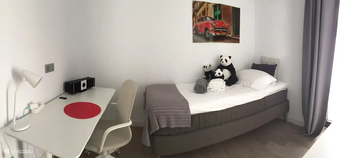 Bedroom 3 with single box spring bed and desk. Air conditioning. blackout curtain. Bed linen is provided. Then you have the bathroom 3.