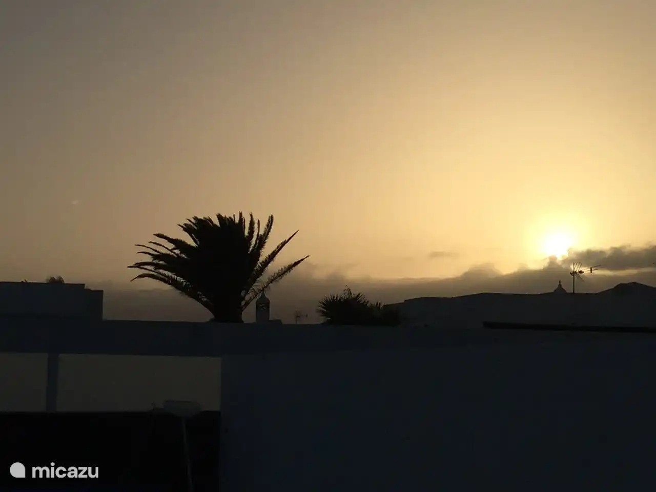 The sun sets at the rear of the house.