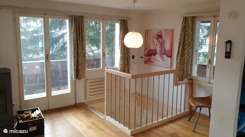 The living room upstairs with the patio doors to the veranda and the stairs down.