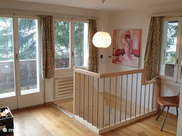 Chalet Belle Hélène | Suisse, Valais, Fiesch - chalet Le salon à l'étage avec les portes-fenêtres vers la véranda et les escaliers vers le bas.