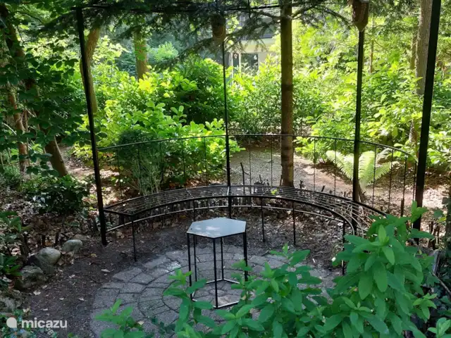 Boshuis huren in Nederland, Drenthe, Wateren - vakantiehuis Op dit bankje kun je de tuin grotendeels overzien vanuit de schaduw.