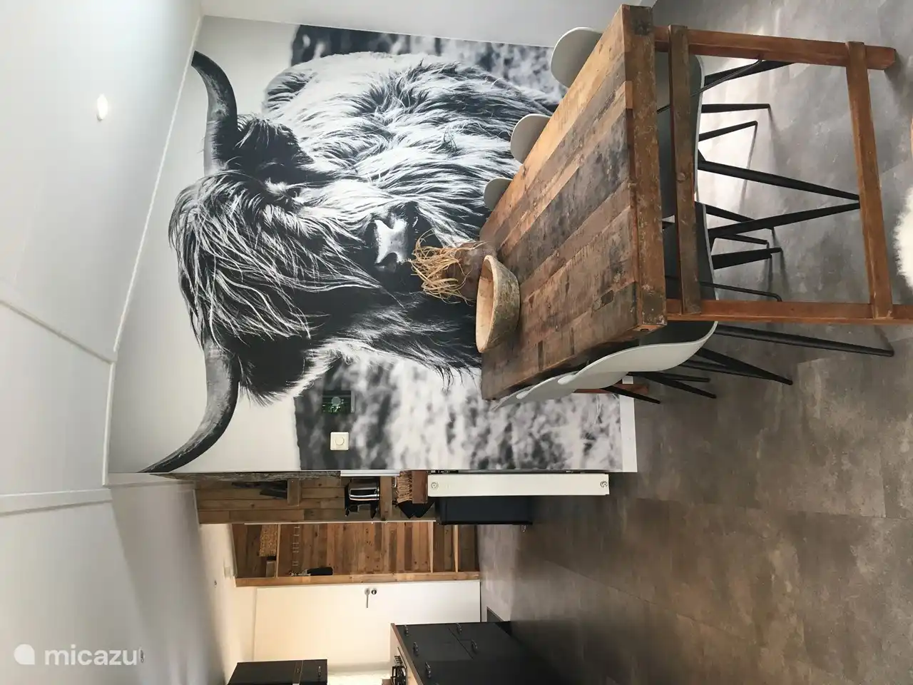 Großer Tisch mit 6 Stühlen und der Highlander schaut zu