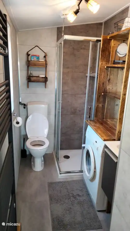 Badezimmer mit ausreichend Ablagemöglichkeiten und Waschmaschine