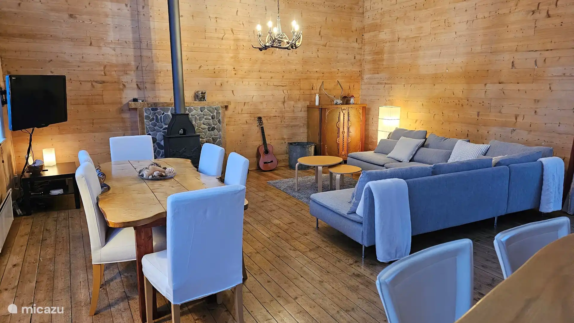 La sala de estar con mesa de comedor, amplio sofá y chimenea.