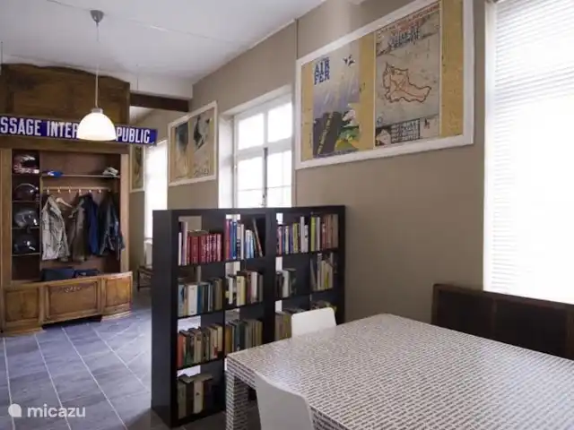 l'Ancienne Gare | France, Vosges, Monthureux-sur-Saône - maison de vacances On entre dans le hall d'entrée, qui est d'ailleurs encore dans son état d'origine, avec les belles affiches publicitaires anciennes, les enseignes émaillées et les comptoirs. Dans le hall d'entrée, un espace a également été aménagé pour une table de travail, et le coin télévision avec écran plat et lecteur DVD.
