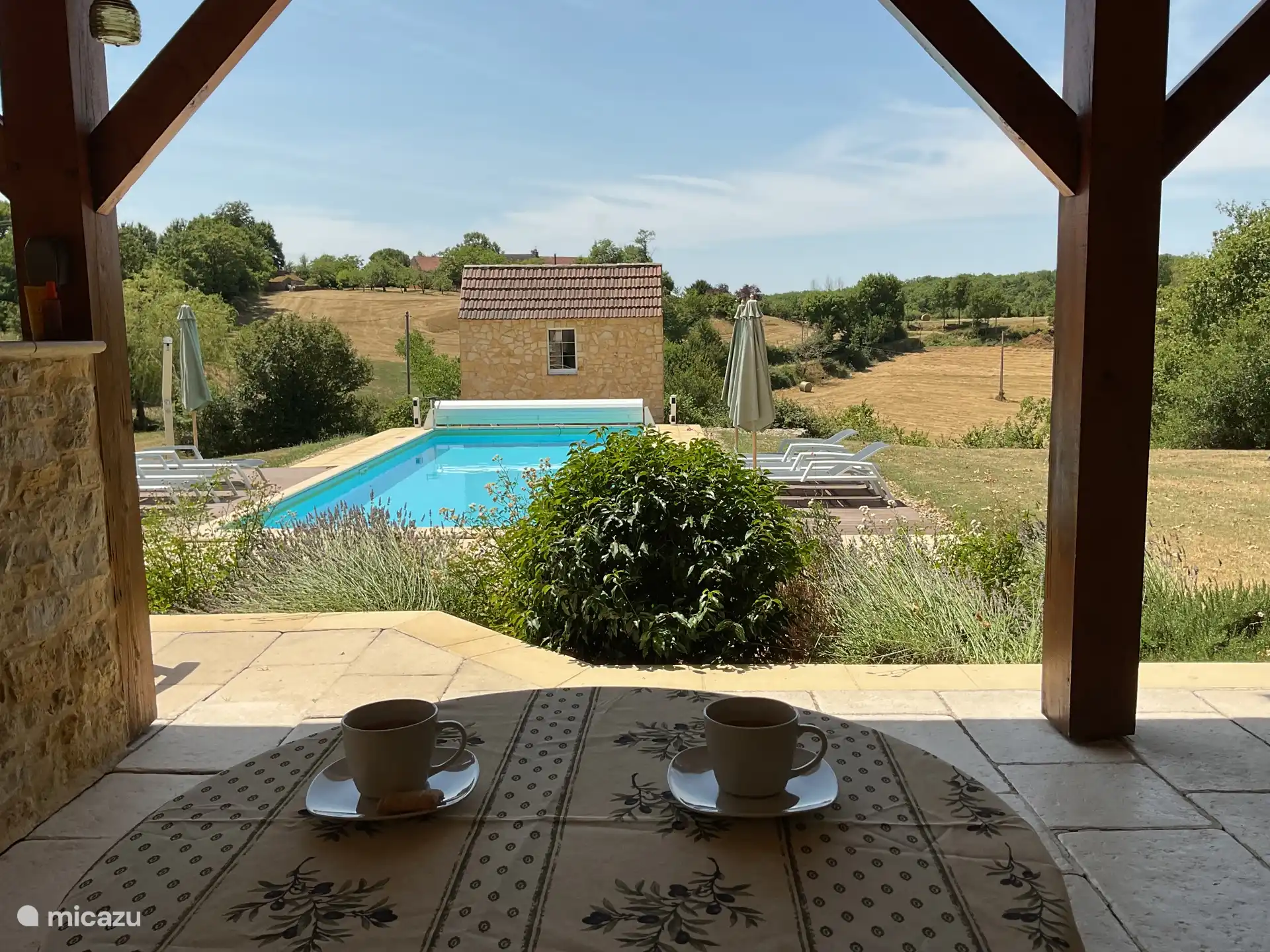 Schöner Blick auf Garten und Pool von der kühlenden Terrasse.