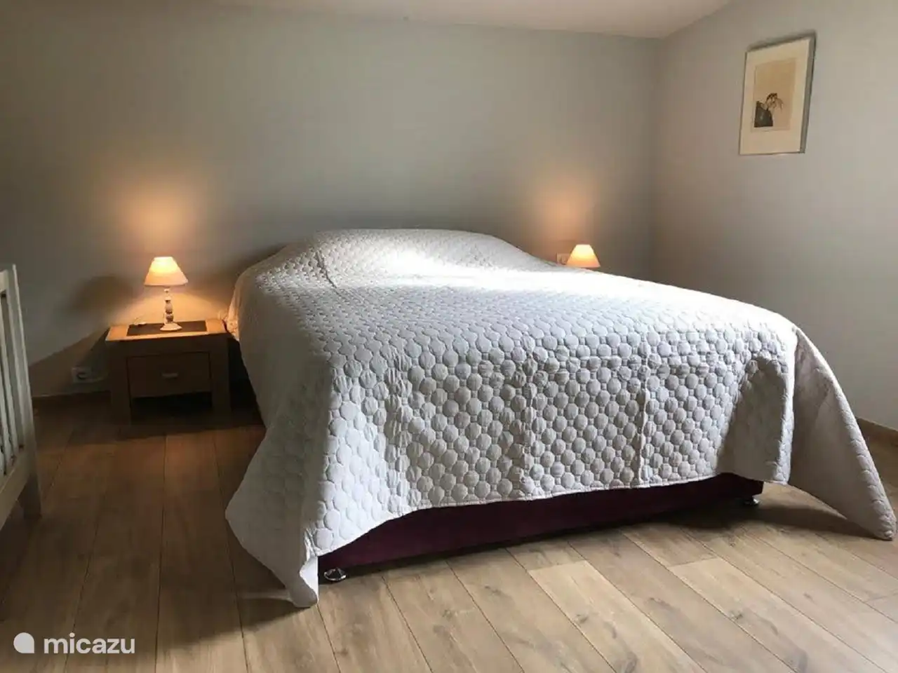 Zimmer mit Boxspringbett und Babybett.