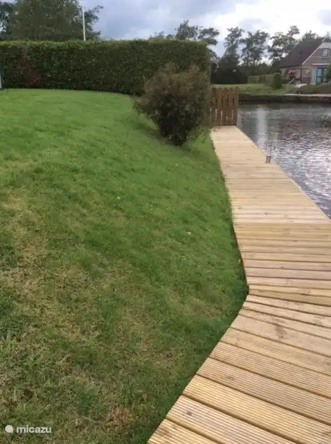 Setzen Sie sich mit den Füßen im Wasser auf den Steg.