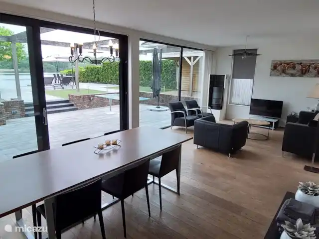 Casa de vacaciones Twente en Países Bajos, Overijssel, Westerhaar - villa Amplia sala y comedor con vista a la terraza y al lago. Las puertas correderas te dan acceso directo a la terraza y la playa.