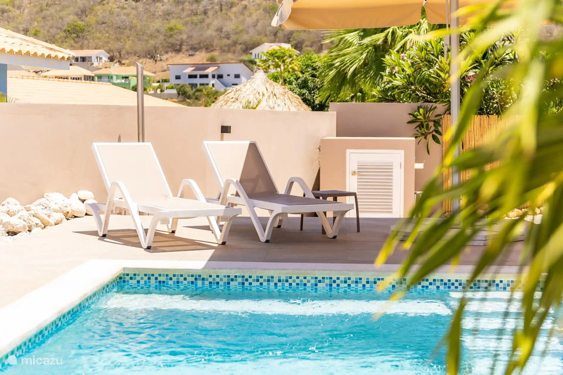 Genieten op de ligbedden bij het zwembad.