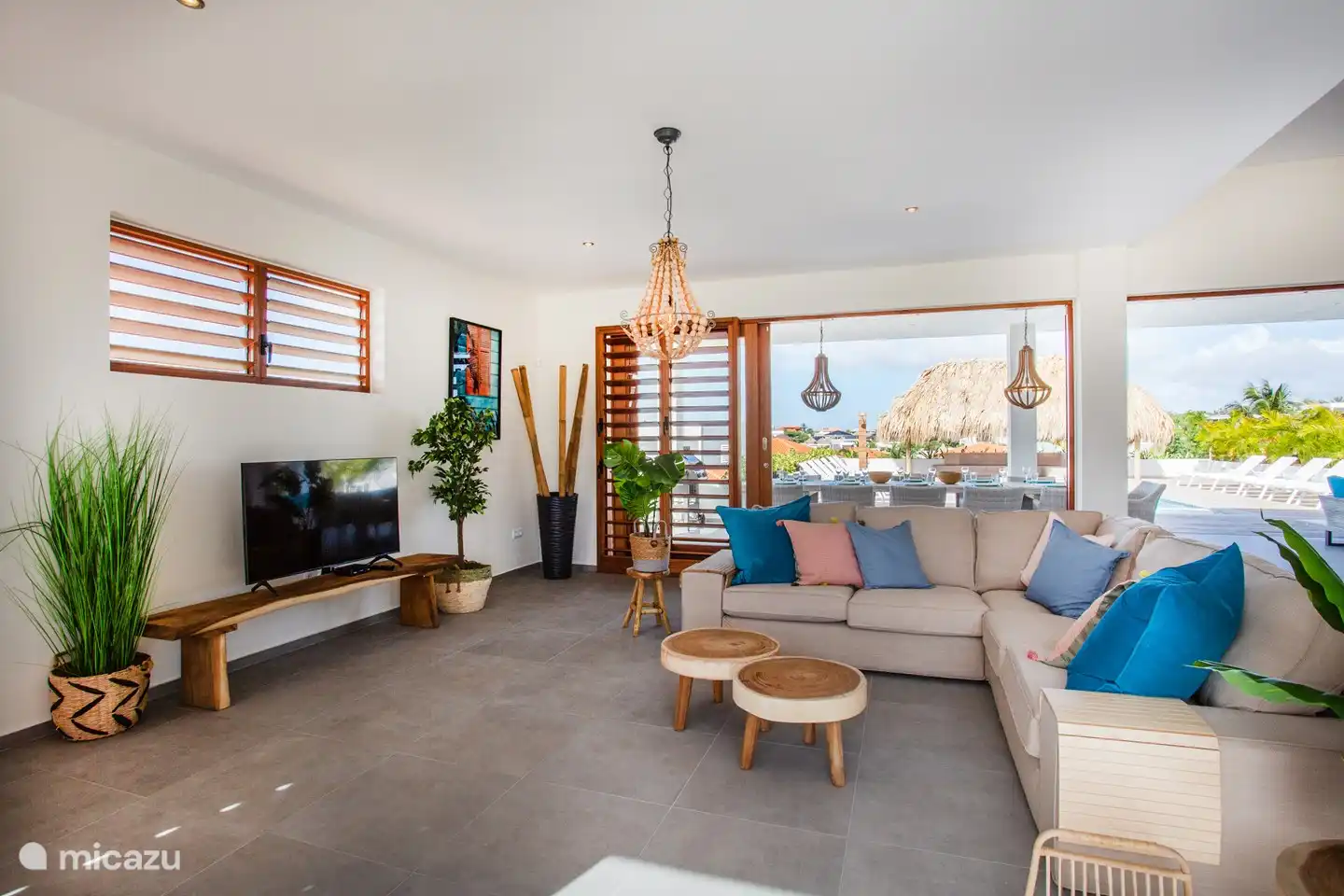 Salon avec portes-fenêtres donnant sur le porche, la piscine et la terrasse.