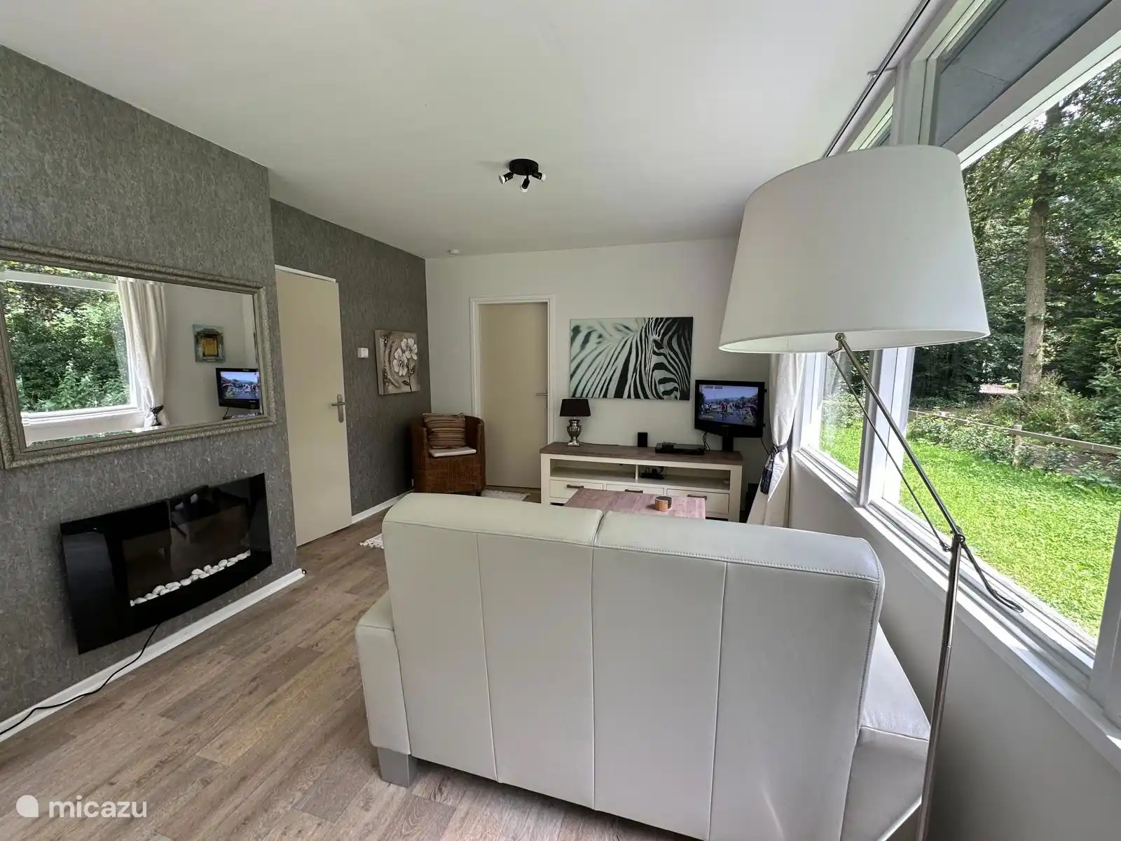 Das Wohnzimmer ist hell und bietet Blick auf den Garten.  Die Eichhörnchen fliegen von Baum zu Baum.