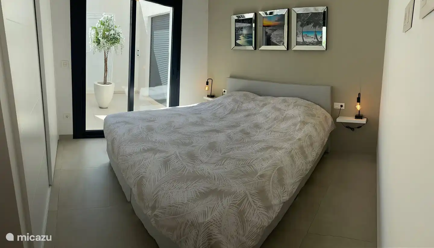 Chambre numéro un avec un grand placard et une vue sur le patio.