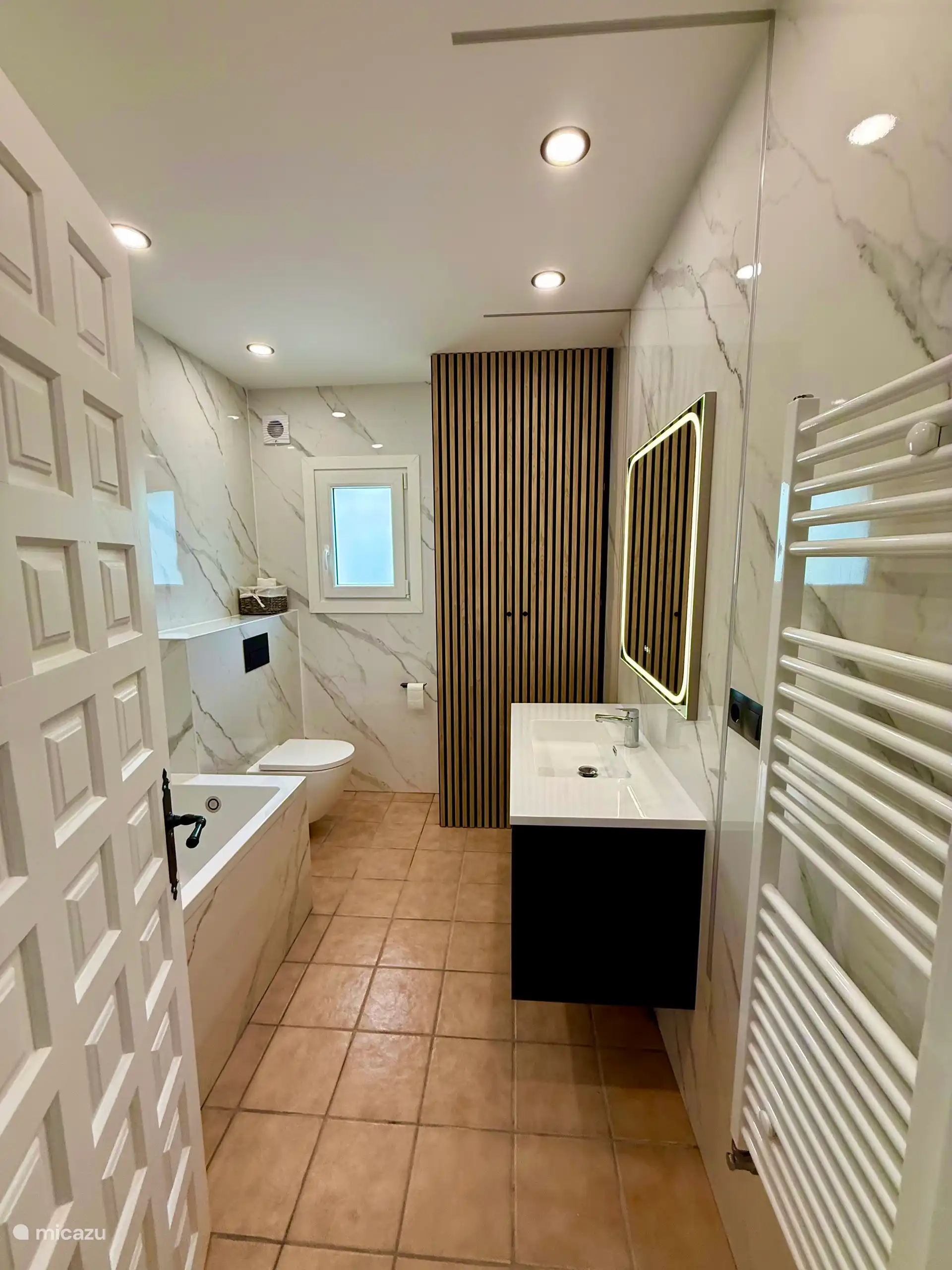 Nouvelle salle de bain avec WC et baignoire.