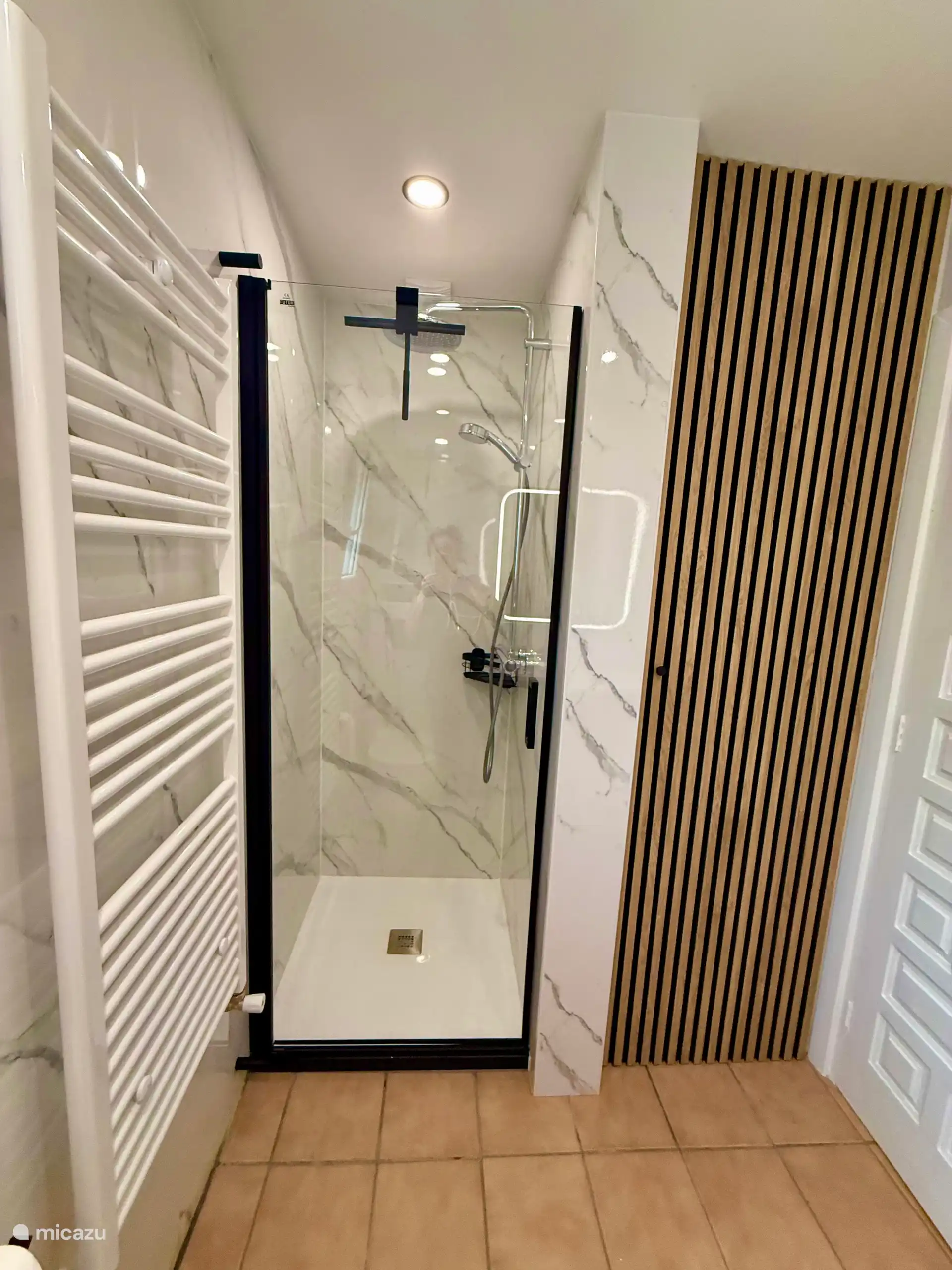 Nouvelle salle de bain avec douche, WC, machine à laver et sèche-linge.