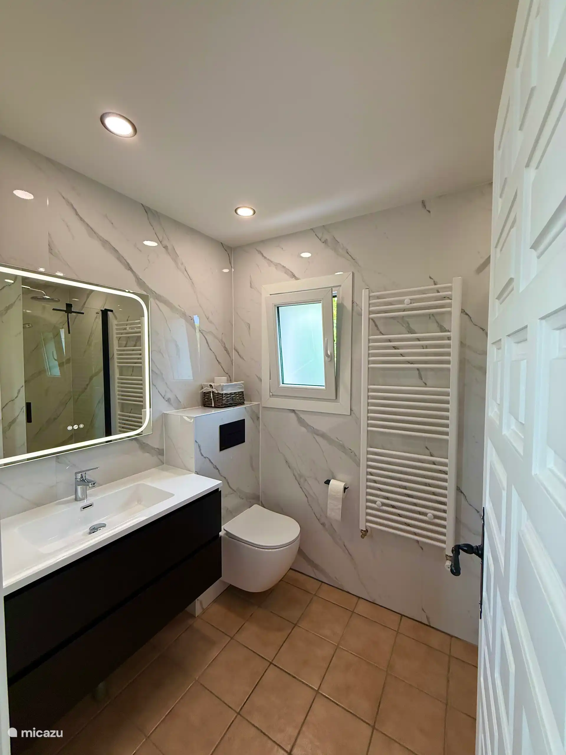 Nouvelle salle de bain avec douche, WC, machine à laver et sèche-linge.