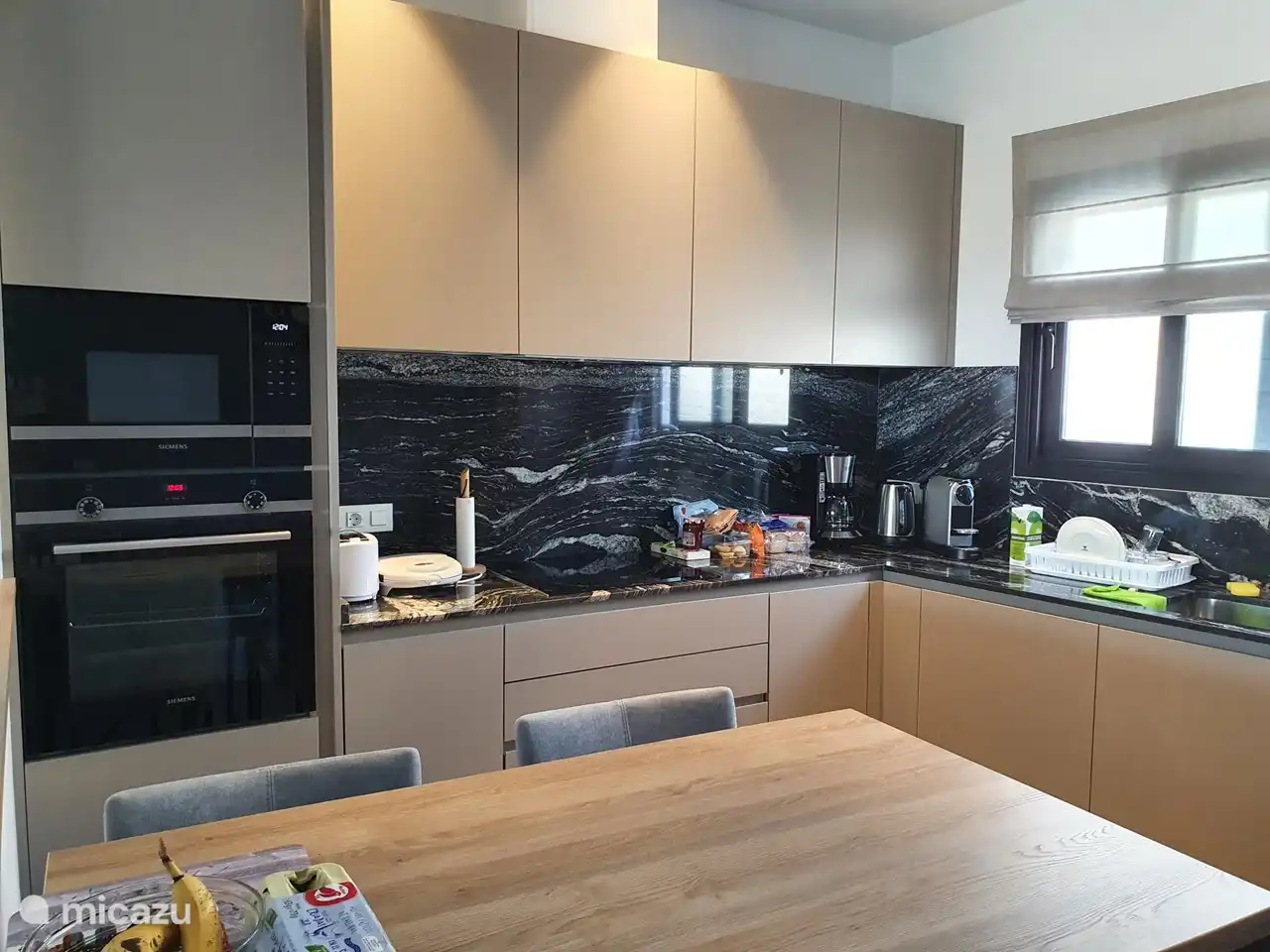 Una cocina abierta con todas las comodidades y electrodomésticos. Todos los dispositivos son de la marca A.