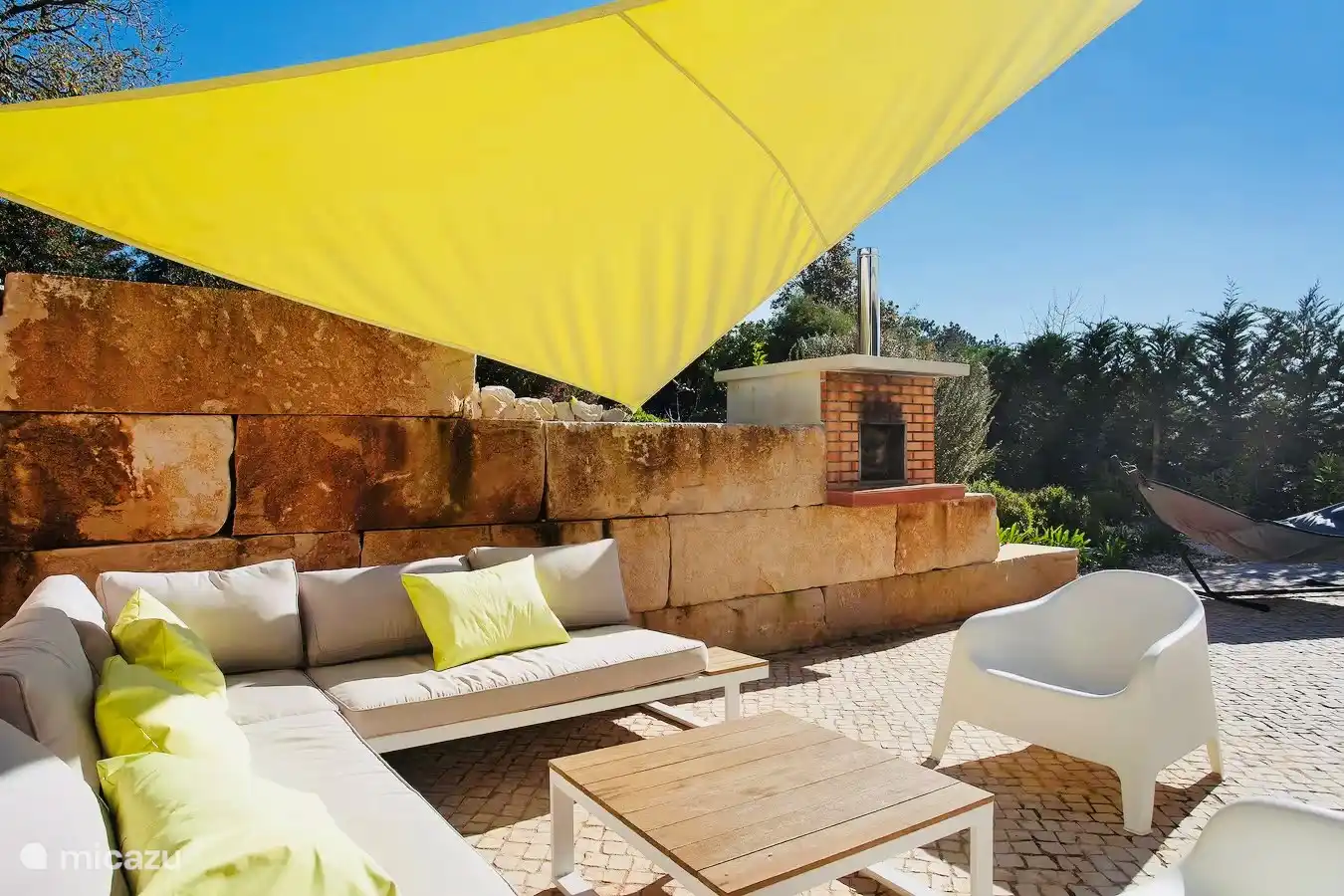 Gezellige hoek met lounge en pizza oven.