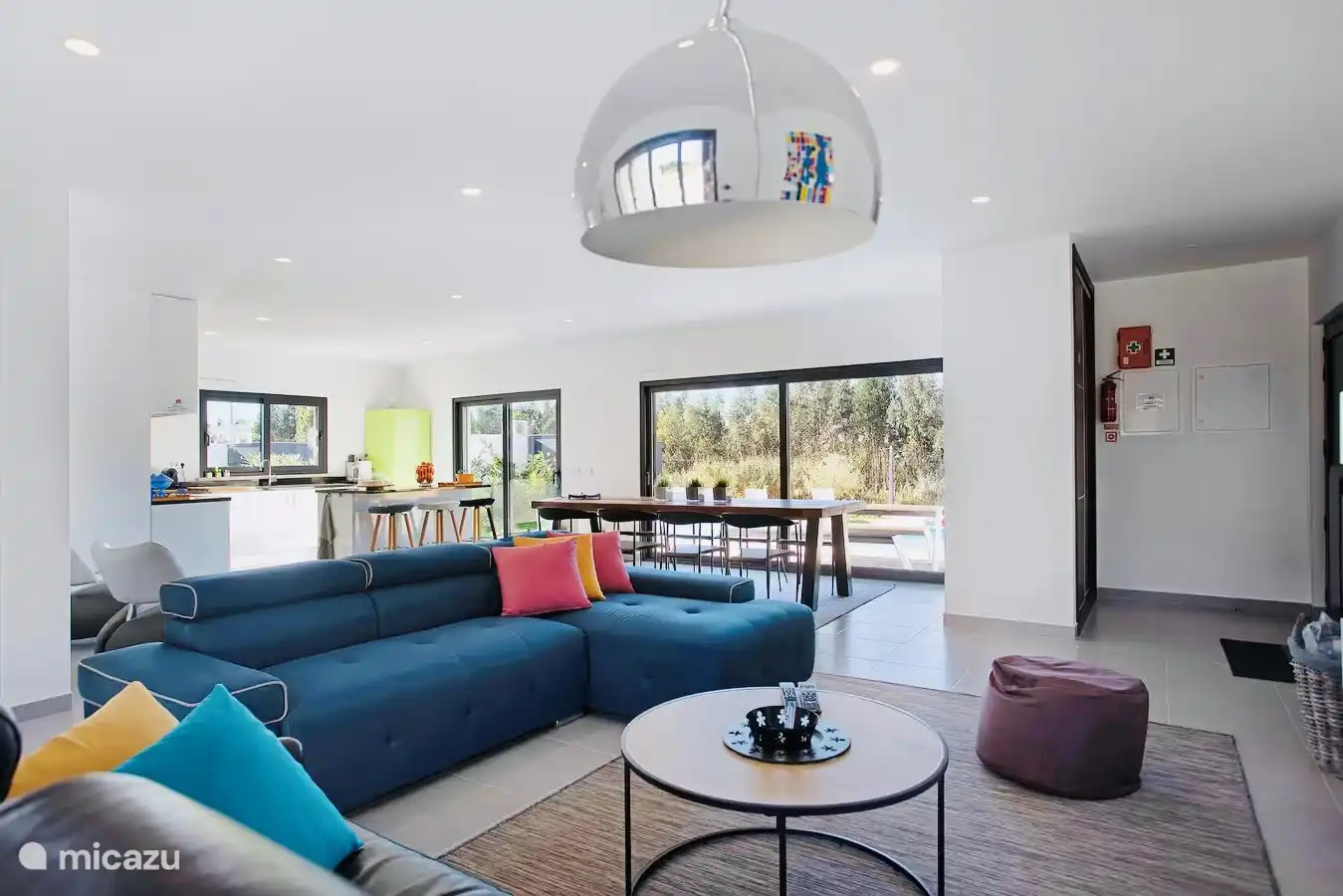 Open leefruimte met zicht op zwembad.