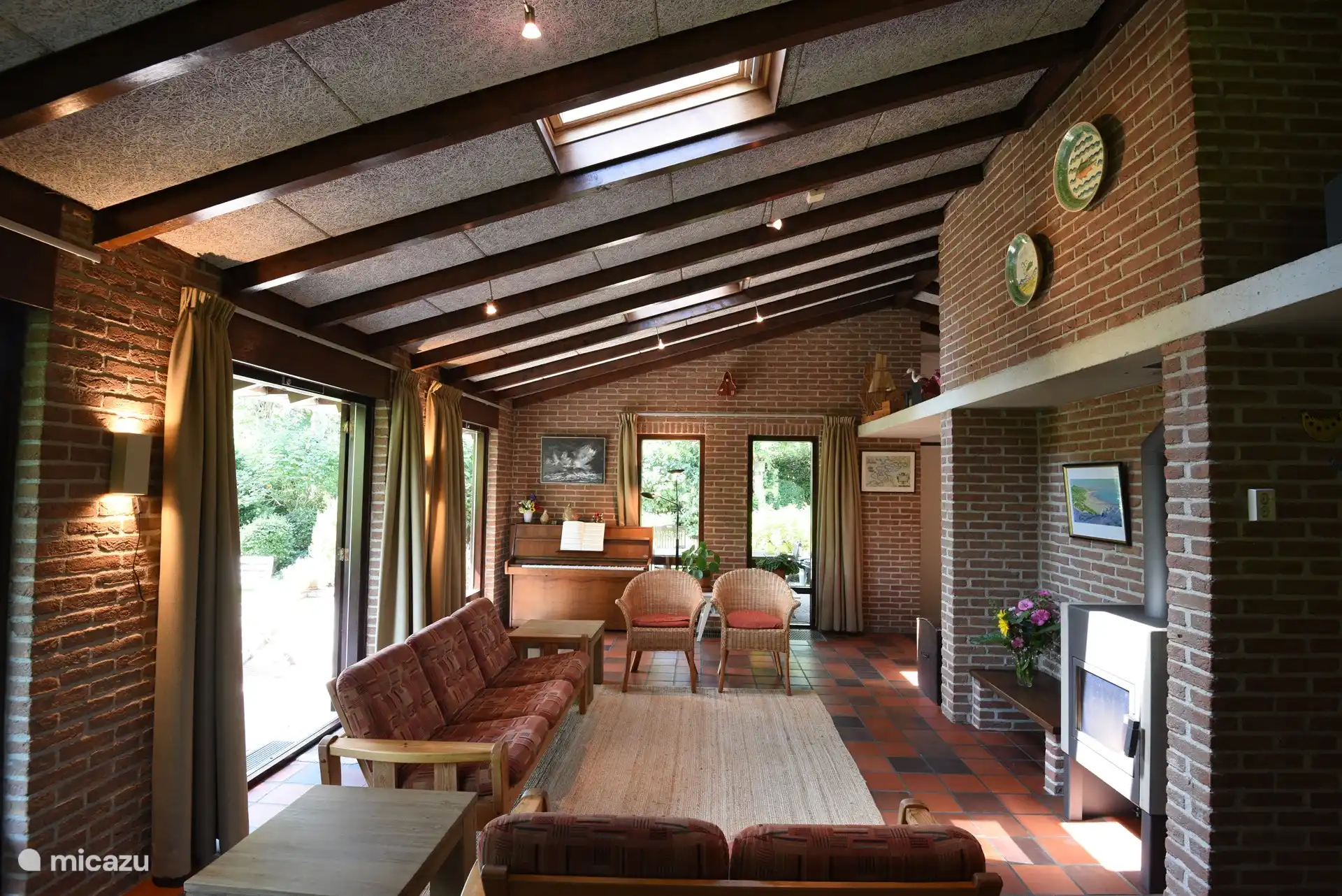 Wohnzimmer mit Holzofen und Klavier