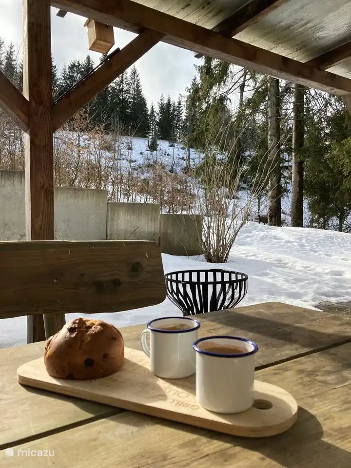 Veranda with wooden tables and benches, large enough for 14 people. 