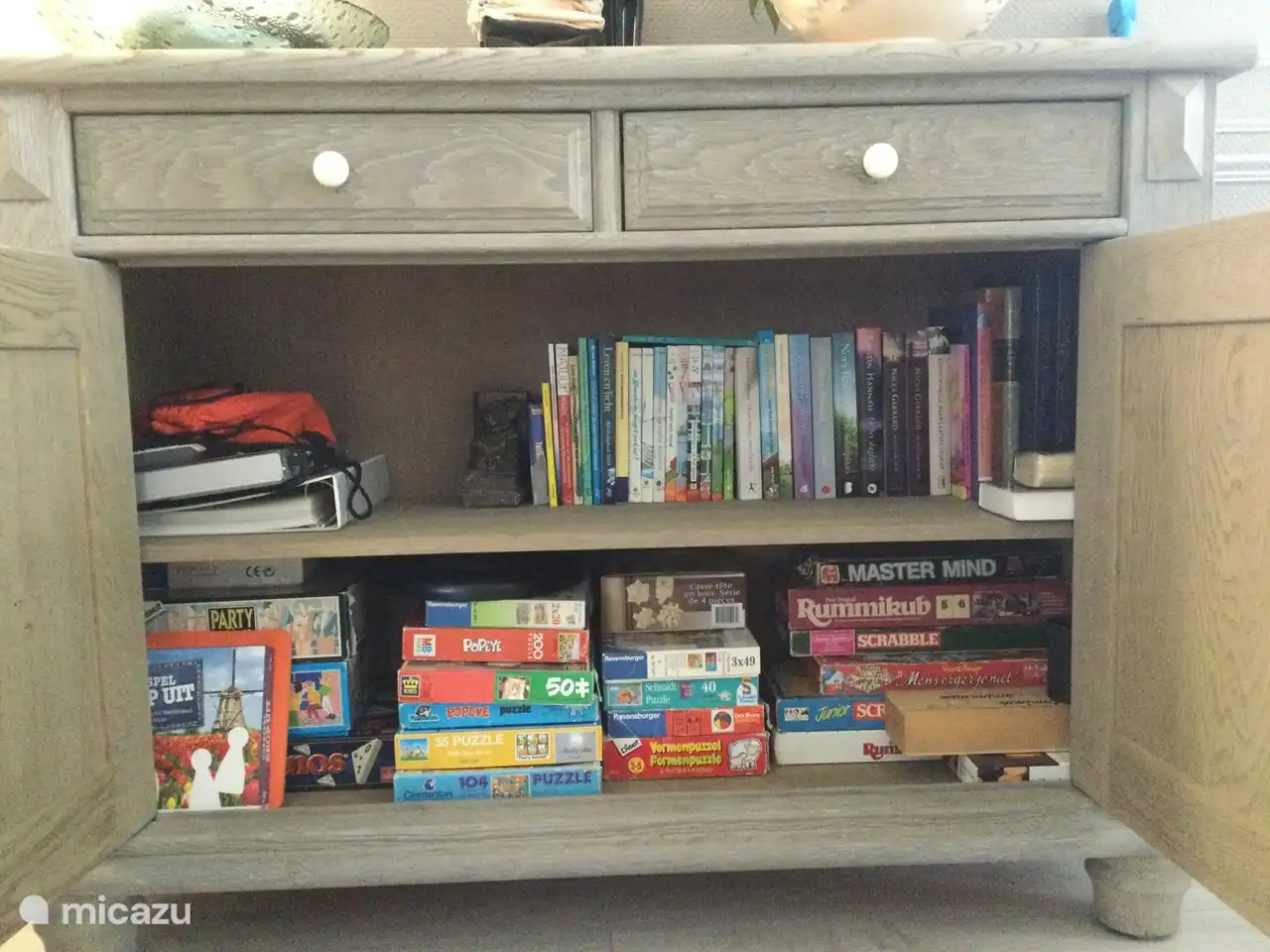 Ein Schrank voller Spiele und Bücher.