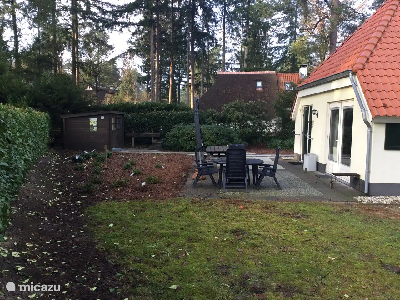 Eine schöne große Terrasse mit Picknicktisch und separatem Tisch mit Stühlen.