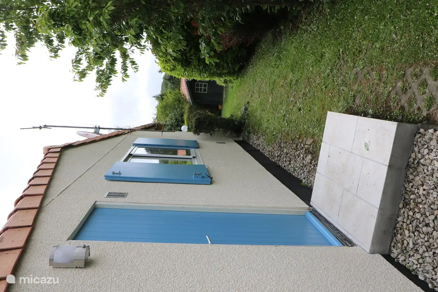 Seite des Bungalows, wo sich der Zugang zum Hauswirtschaftsraum befindet. Es gibt eine Waschmaschine/Trockner-Kombination und einen zusätzlichen Kühlschrank mit Gefrierfach