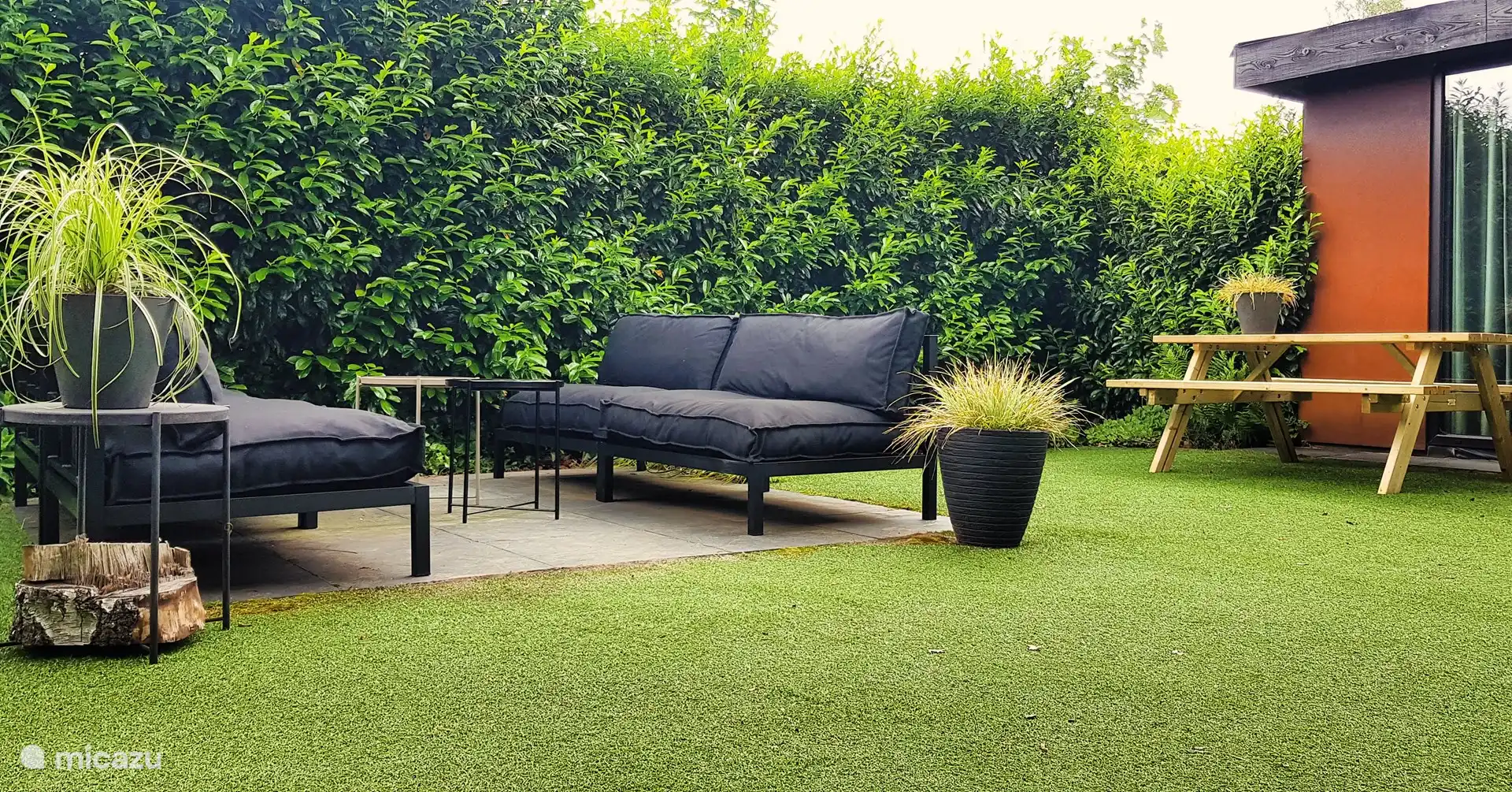 Setzen Sie sich draußen auf die entspannten Lounge-Sofas im eingezäunten Garten