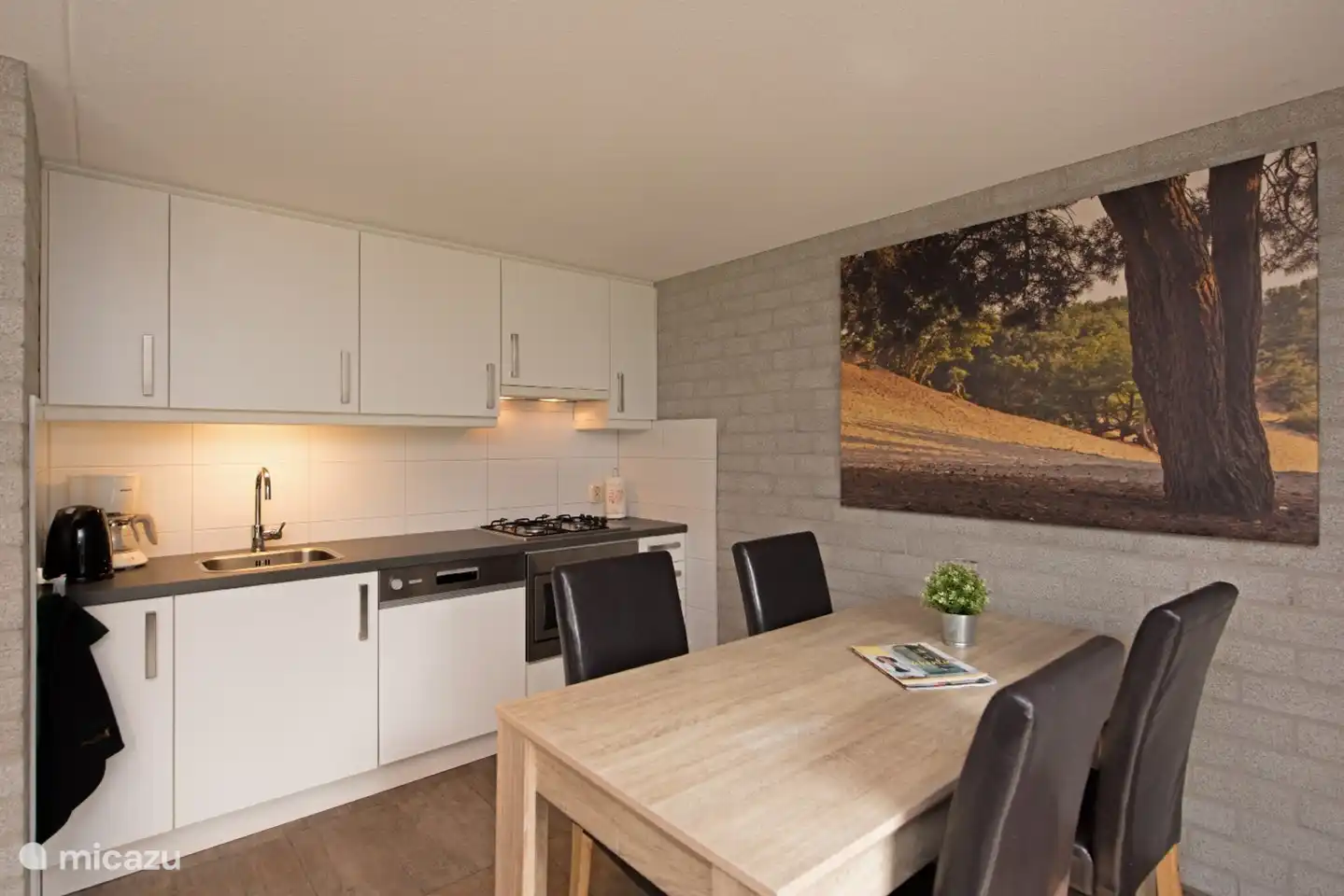 Esstisch mit der voll ausgestatteten Küche