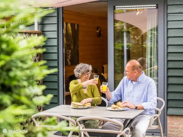 Paon bleu | Pays-Bas, Brabant-Septentrional, Heesch - bungalow Savourez un délicieux petit-déjeuner ensemble dans le jardin le matin.