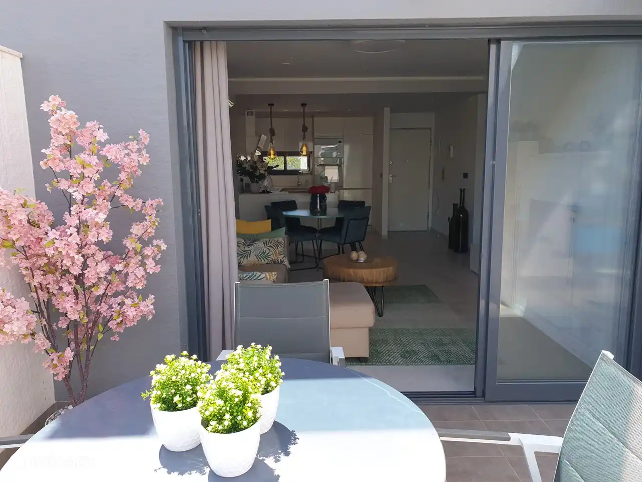En la pequeña terraza adyacente a la sala de estar hay una mesa redonda con 2 sillas. Se ha colocado un trastero debajo de las escaleras. Esta terraza está ubicada en el lado norte y brinda frescura durante las horas cálidas del día.