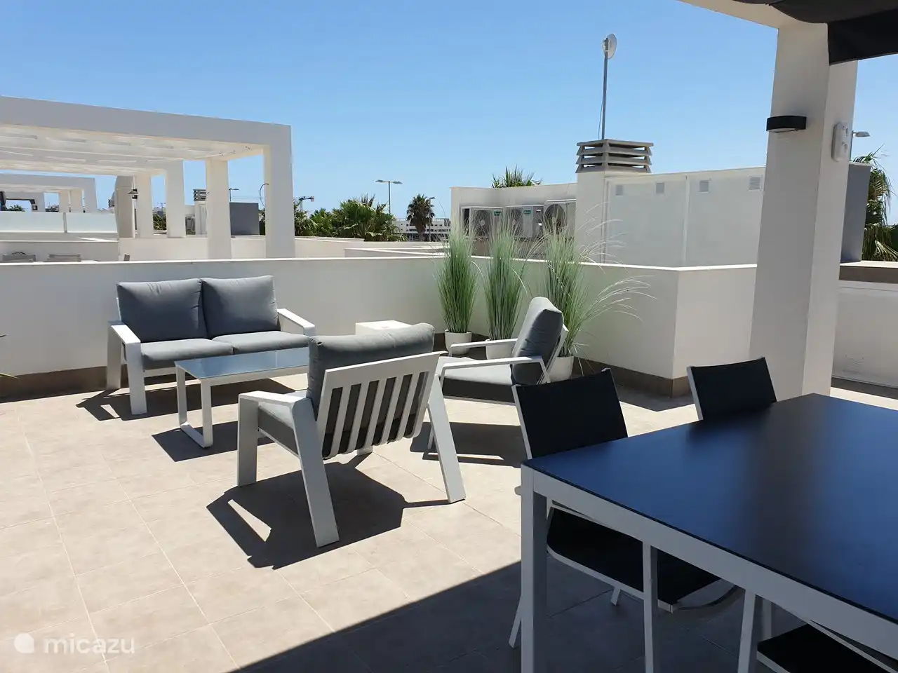 La terraza de la azotea de 70 m2 está equipada con una cocina exterior con barbacoa de gas y fregadero, una barra alta con 2 taburetes, un comedor para 4 personas que incluye toldos horizontales, 2 tumbonas con cojines de sol de lujo, una cómoda sala de estar con un sofá para 2 personas y 2 sillones separados. Ducha exterior con agua caliente.