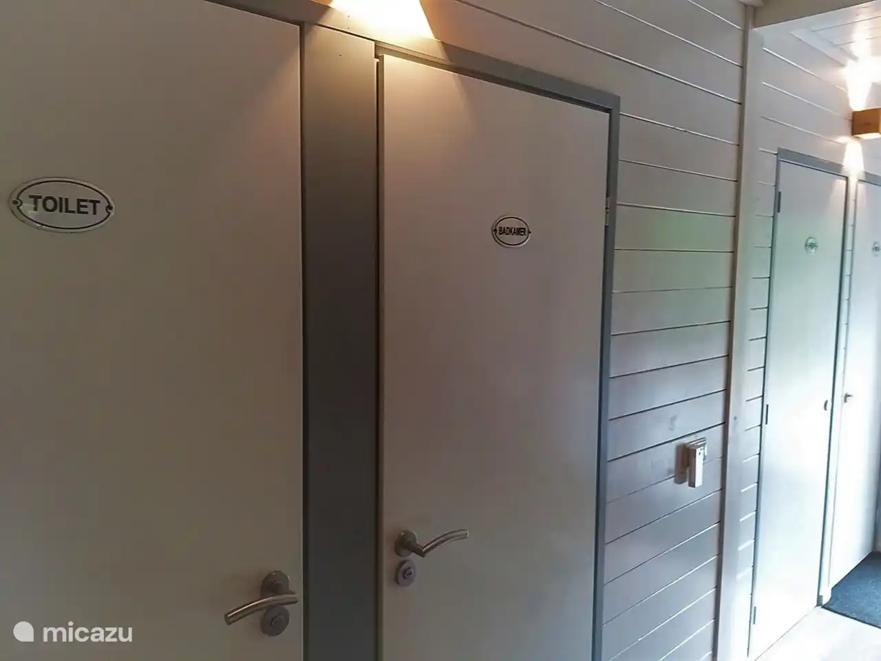 Der geräumige Eingang mit Türen zum Schlafzimmer im Erdgeschoss, das Badezimmer und die Toilette. In der Halle finden Sie auch die Treppe zum ersten Stock des Forsthauses De Toekan.