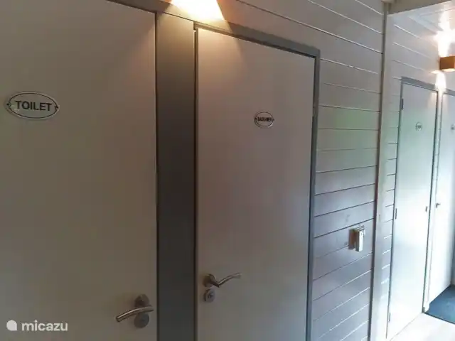 el tucan en Países Bajos, Güeldres, Emst (Epe) - casa vacacional La amplia entrada con puertas al dormitorio en la planta baja, el baño y el aseo. Las escaleras al primer piso de la casa forestal De Toekan también se encuentran en el pasillo.