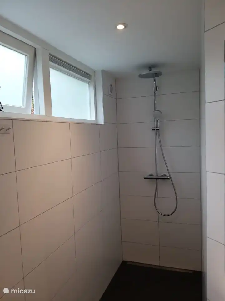 Das Badezimmer mit großzügiger ebenerdiger Dusche und ausreichender Belüftung.