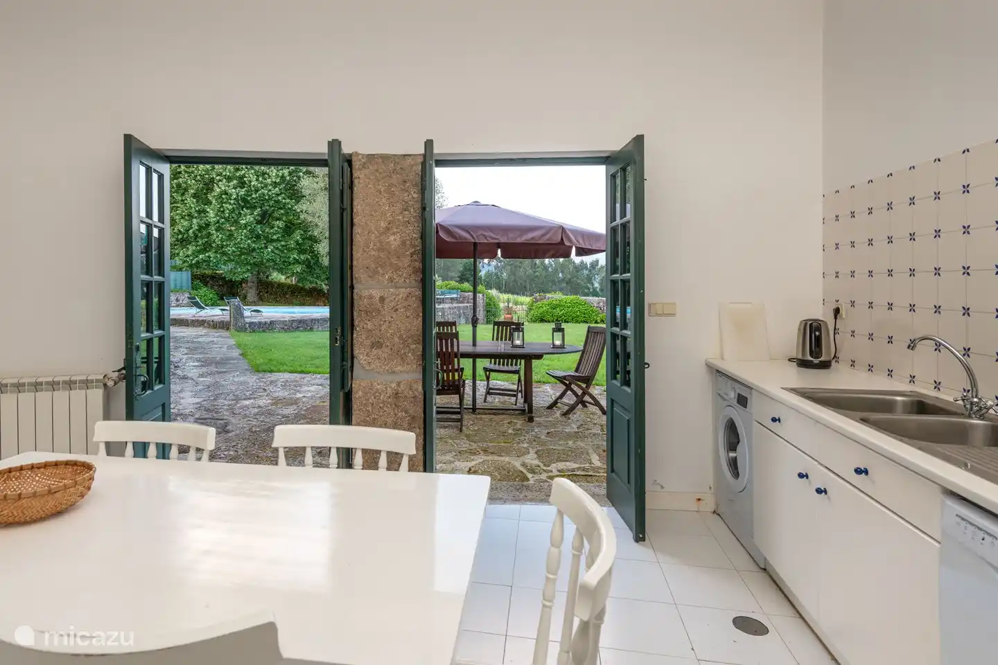 Die geräumige Küche verfügt über alle Annehmlichkeiten, einen Esstisch und direkten Zugang zur Terrasse und zum Garten.