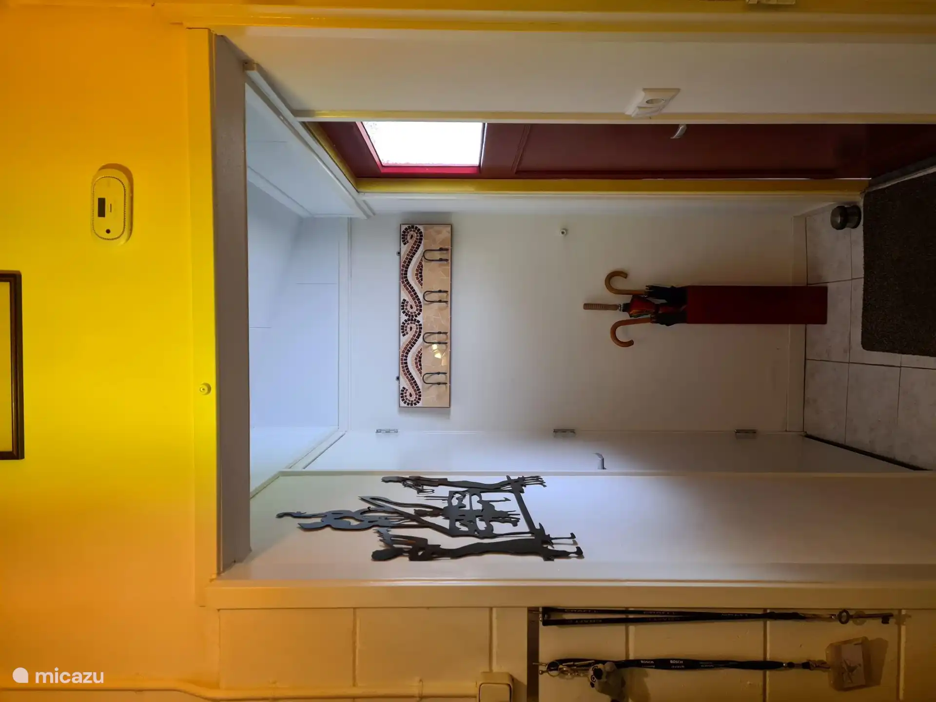 New hall with coat rack, umbrella stand and door to new bathroom.