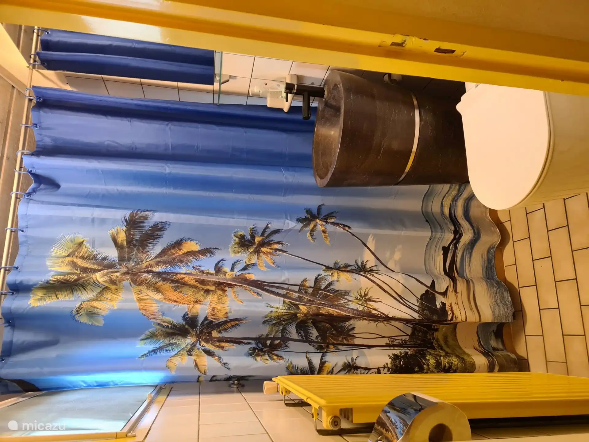Toilet room with sink and behind the curtain a washing machine and drying rack.