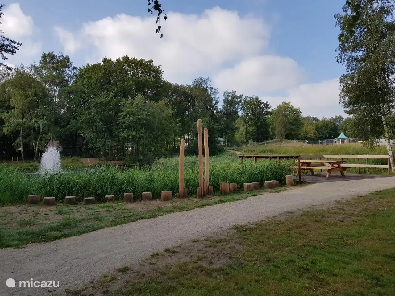 Renewed walking path around pond with picnic table.