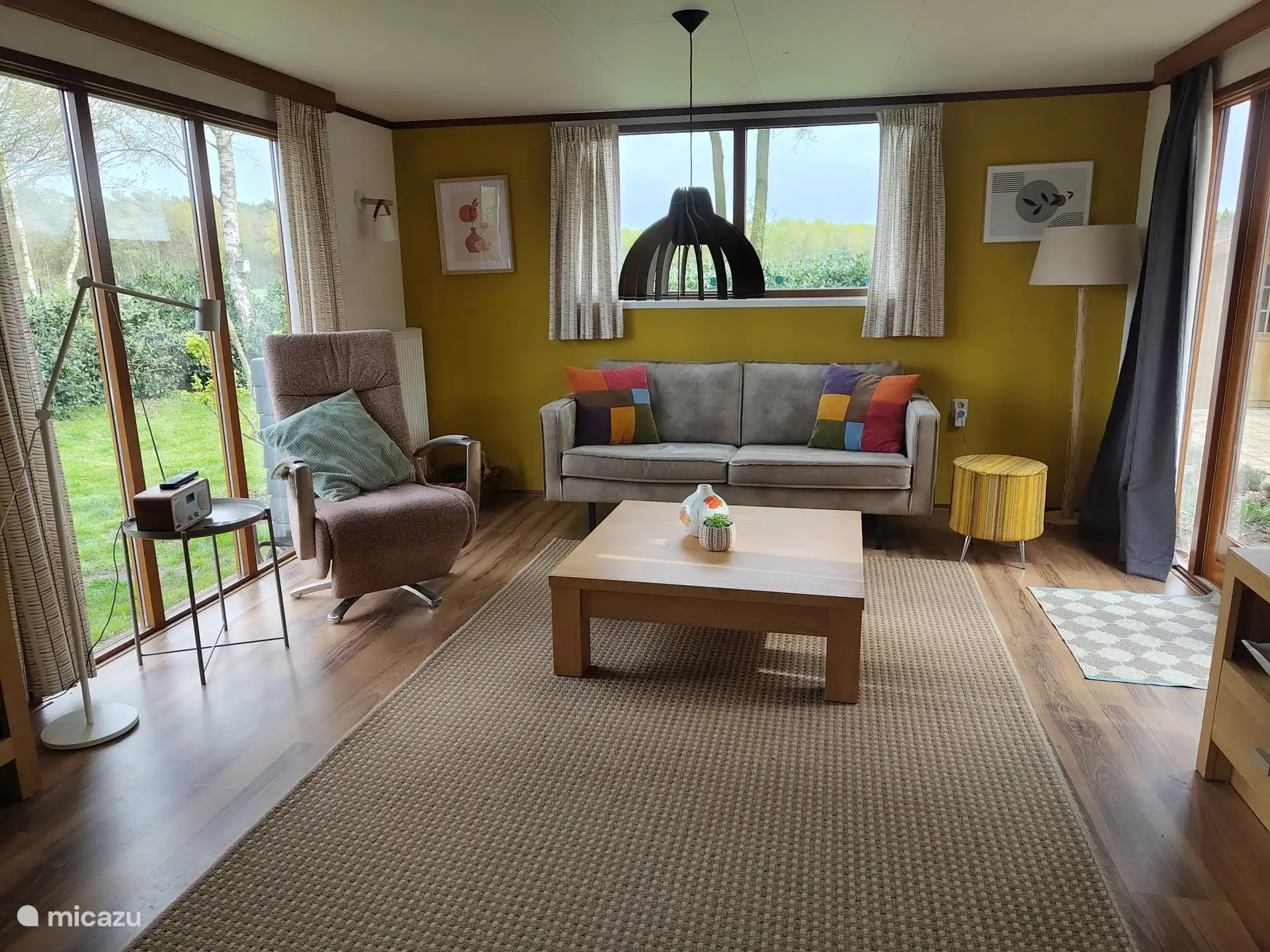 Wohnzimmer mit Sofa für zwei Personen und Liegesessel