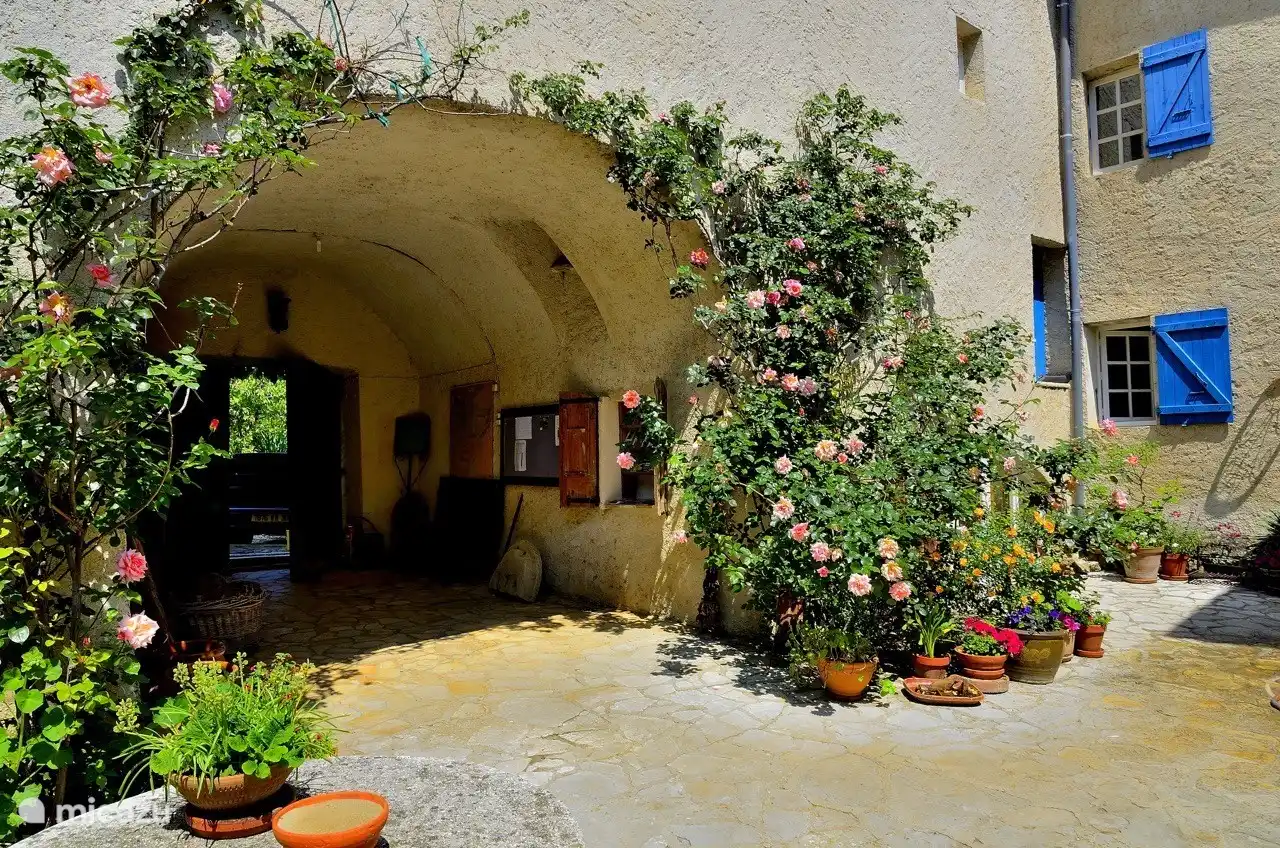 De binnenplaats met links de entreepoort. Hier staan ook de broodkist waarin de bakker dagelijks verse broodjes aflevert en de kast met folders.