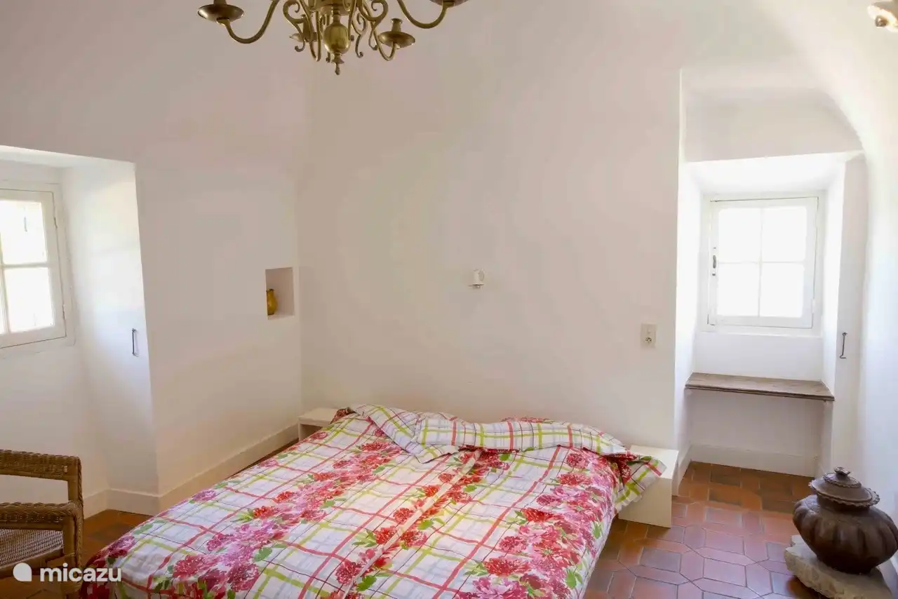 De tweede slaapkamer.  Met kroonluchter en zachtgeel geschilderd meubilair.