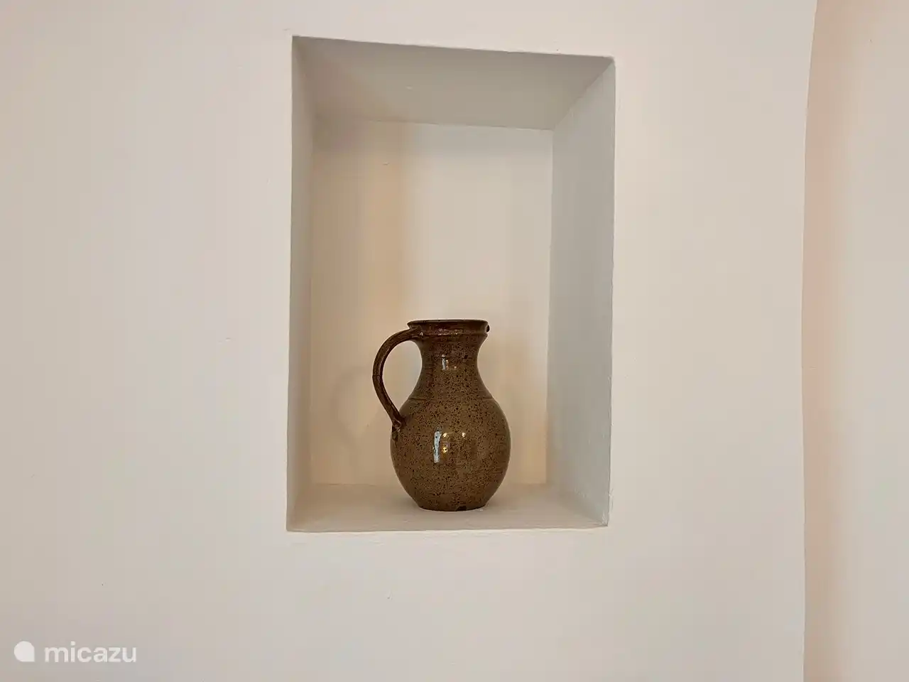 Aardewerk komt mooi uit in de muur nis.
